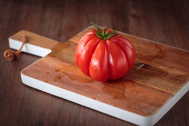 tomate crue sur une planche en bois